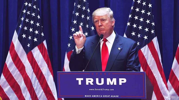 Man speaking at podium with USA flags behind him.