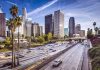 City skyline with freeway and palm trees.