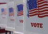 Voting booths with American flags and "VOTE" signs.