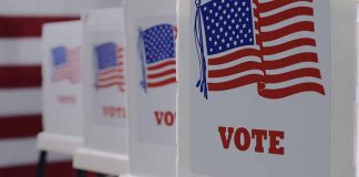 Voting booths with American flags and "VOTE" signs.