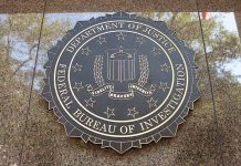 FBI seal on marble wall in daylight.