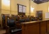 Empty courtroom jury seats with wood paneling.