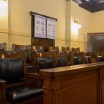 Empty courtroom jury seats with wood paneling.