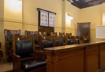 Empty courtroom jury seats with wood paneling.