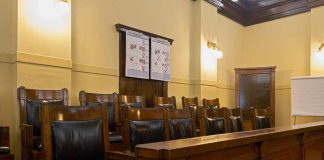 Empty courtroom jury seats with wood paneling.