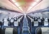 Empty airplane cabin with rows of seats.