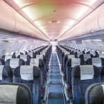 Empty airplane cabin with rows of seats.