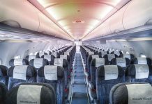 Empty airplane cabin with rows of seats.