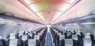 Empty airplane cabin with rows of seats.