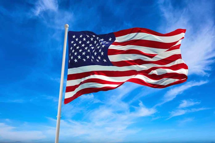 American flag waving against a blue sky.