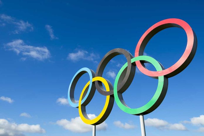 Olympic rings sculpture against blue sky.