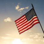 American flag waved against sunset sky.