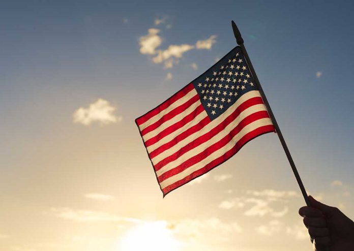 American flag waved against sunset sky.