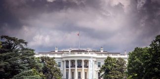 White House front view with dark clouds above.