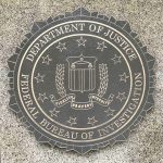 FBI emblem on Department of Justice building wall.