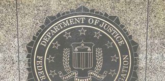 FBI emblem on Department of Justice building wall.