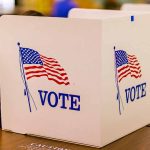 Voting booth with American flag and "VOTE" text.