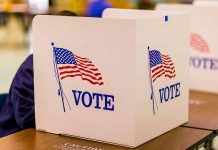 Voting booth with American flag and "VOTE" text.