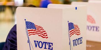 Voting booth with American flag and "VOTE" text.