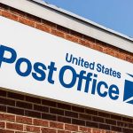 United States Post Office sign on brick building.