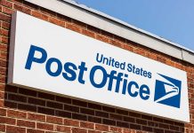 United States Post Office sign on brick building.