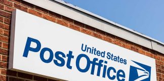 United States Post Office sign on brick building.