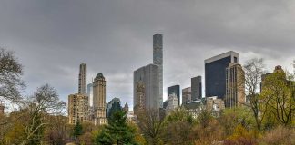 People relaxing in a park, city skyline background.