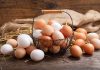 Brown and white eggs in a wire basket.