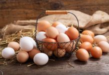 Brown and white eggs in a wire basket.