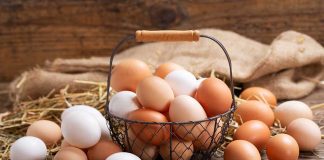 Brown and white eggs in a wire basket.