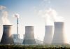 Four cooling towers of a power plant emitting steam.