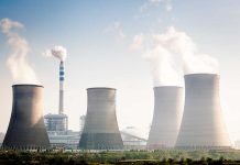 Four cooling towers of a power plant emitting steam.