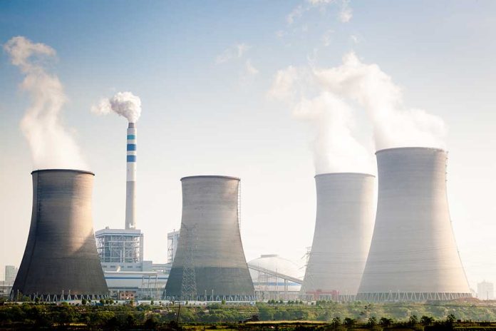 Four cooling towers of a power plant emitting steam.