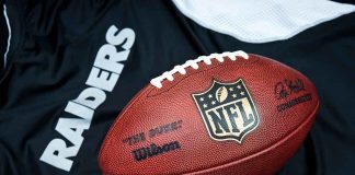 NFL football on Raiders jersey background.