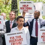 People holding signs about migrant crisis and employment