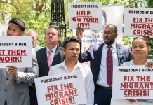 People holding signs about migrant crisis and employment