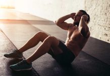 Man performing sit-ups in a gym setting.