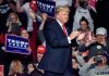 Person clapping at a political rally event.