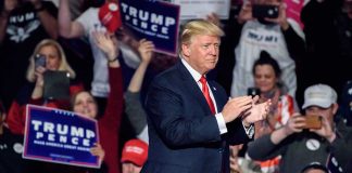 Person clapping at a political rally event.