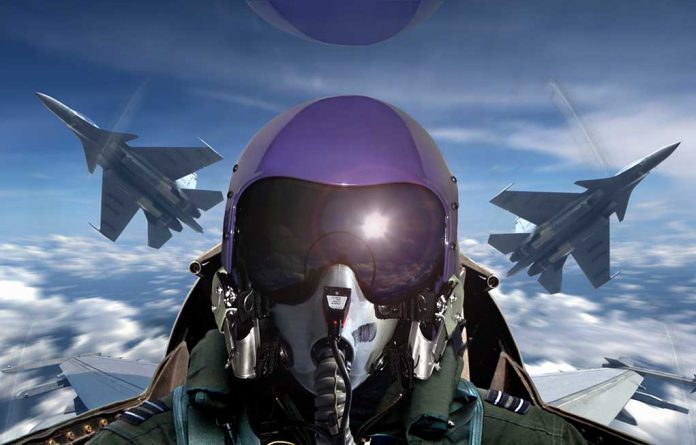 Pilot in cockpit with two fighter jets outside.