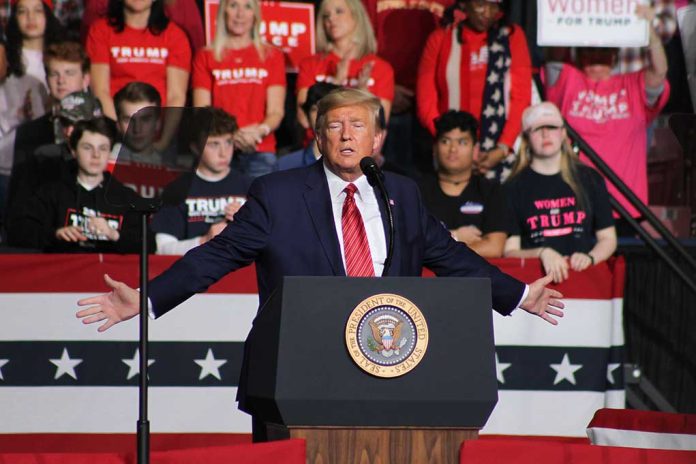 Politician speaking at rally with supporters behind him.