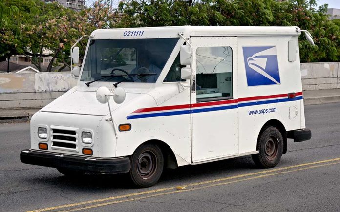 USPS mail truck driving down the street.