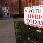 "Vote Here Today" sign outside a building entrance.