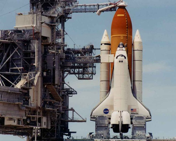 Space shuttle on launch pad with support structure.