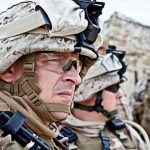 Military personnel in camouflage gear and helmets outdoors