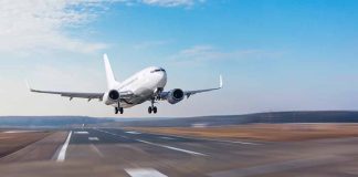 Airplane landing on runway under clear blue sky