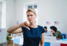 Woman with thumbs down in voting location.