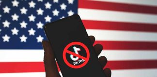 Phone displaying TikTok ban symbol in front of flag