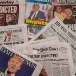 Newspaper headlines about Trump indictment and charges.