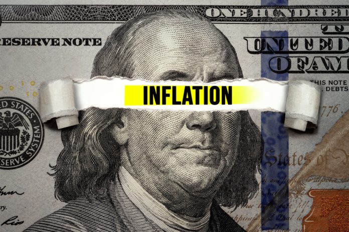 "Inflation" text over torn hundred-dollar bill.